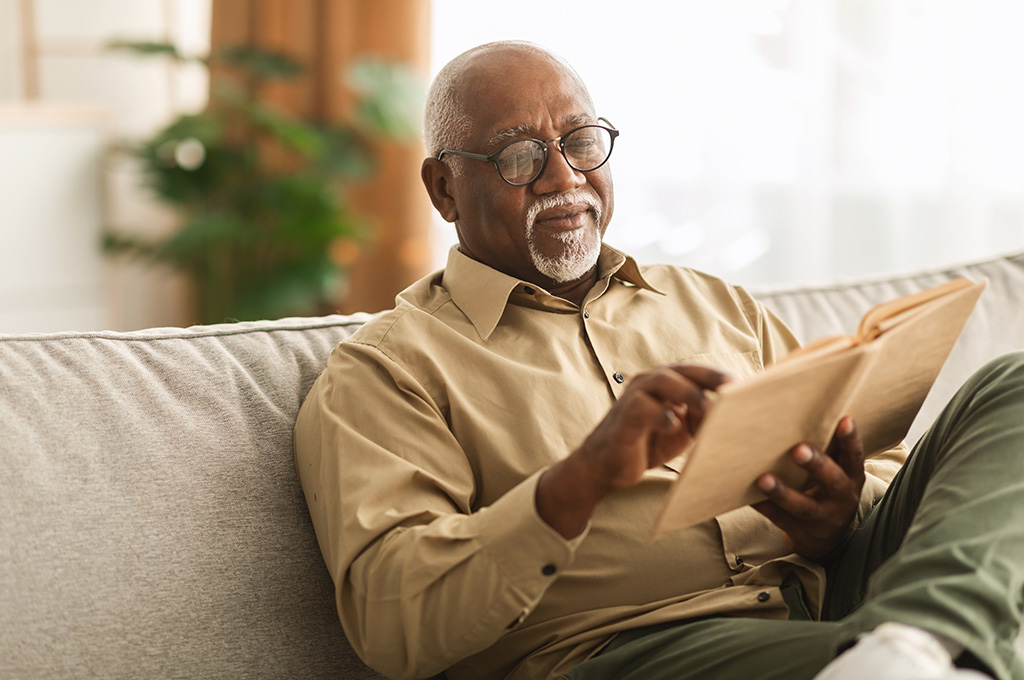 A veteran reads a book at home while enjoying the retirement benefits of ssdi for veterans.