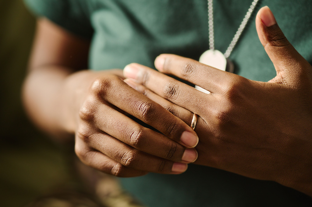 A military service member removing their wedding ring.