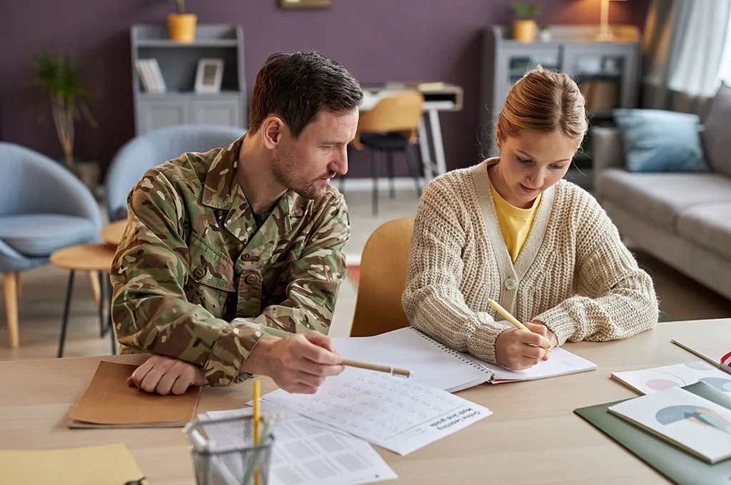 A veteran helps his daughter with homework