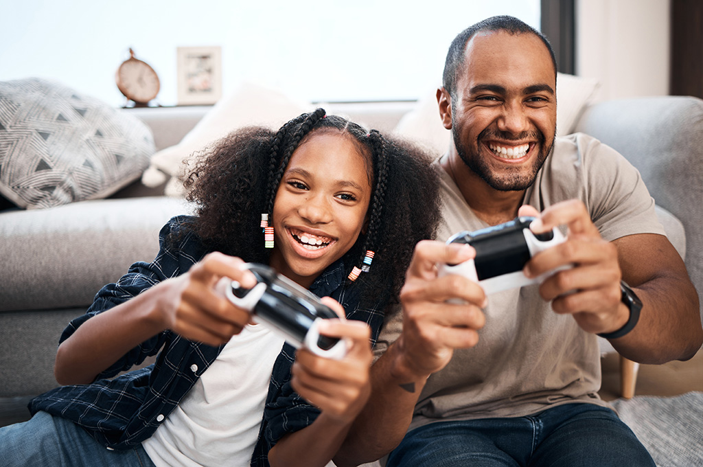 A veteran and his daughter playing video games together