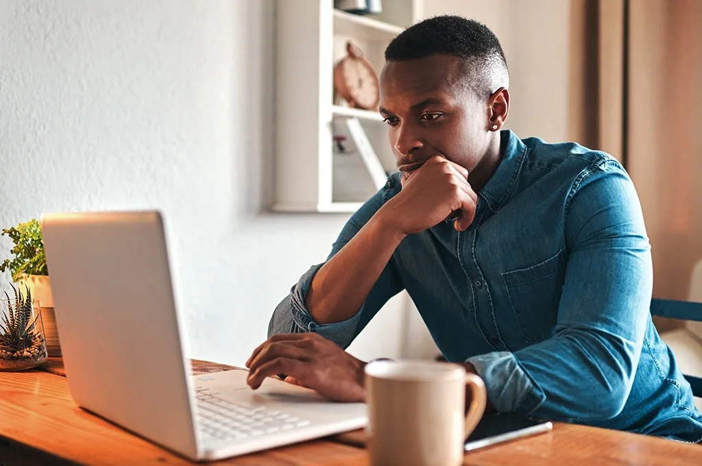A veteran examines the best savings accounts for veterans on his laptop at home