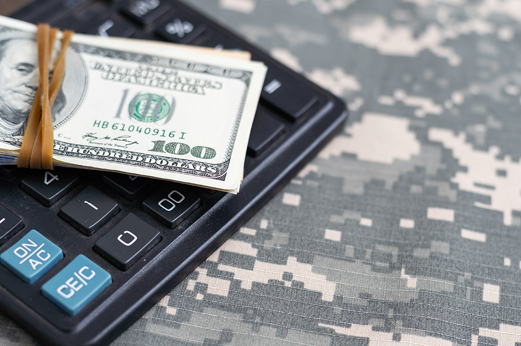 Money and a calculator on an ACU uniform