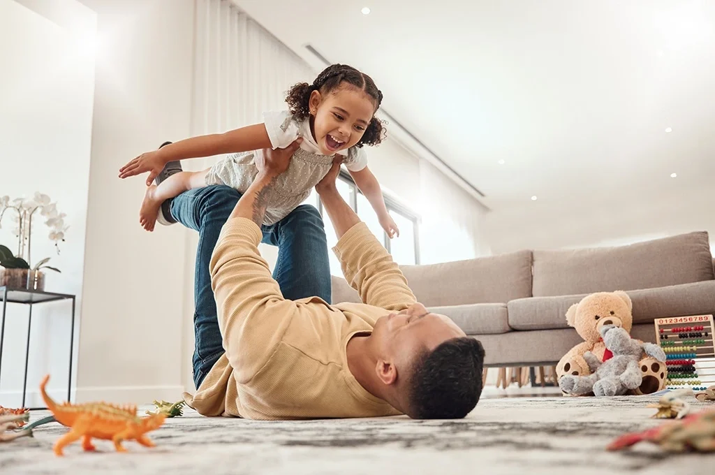 A veteran plays with his daughter at home