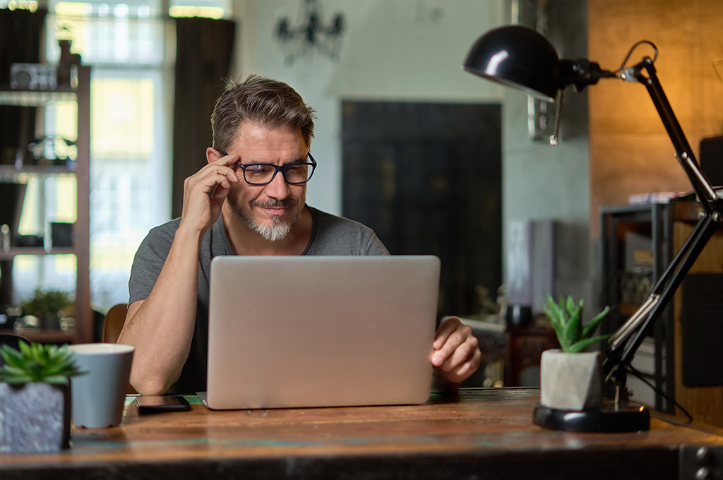A veteran at home looking at debt relief options online