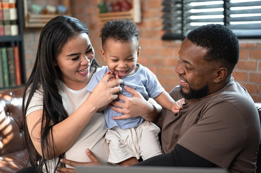 Happy veteran parents holding baby.