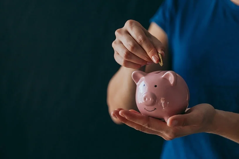 Veteran adding a coin to his piggy bank