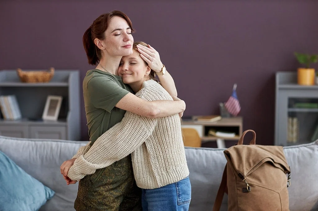 A veteran mother embraces her daughter