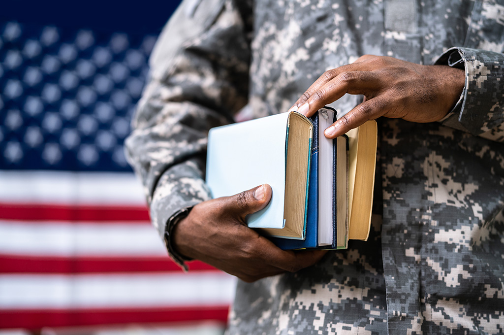 Veteran holding books to learn about maximizing their GI Bill.