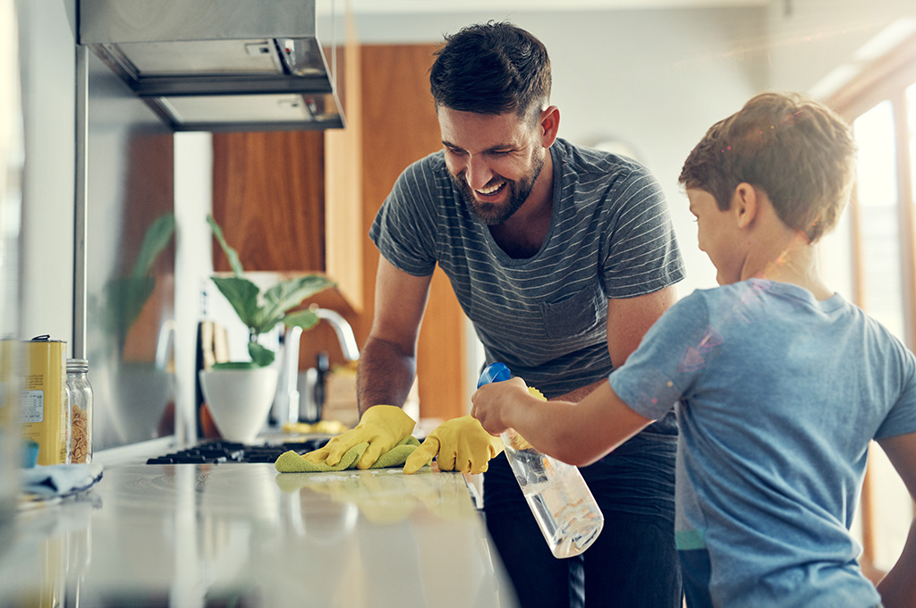 A veteran at home cleaning the kitchen with his son after his transition to civilian life