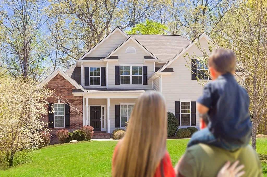 Veteran family looking at their home from the front lawn
