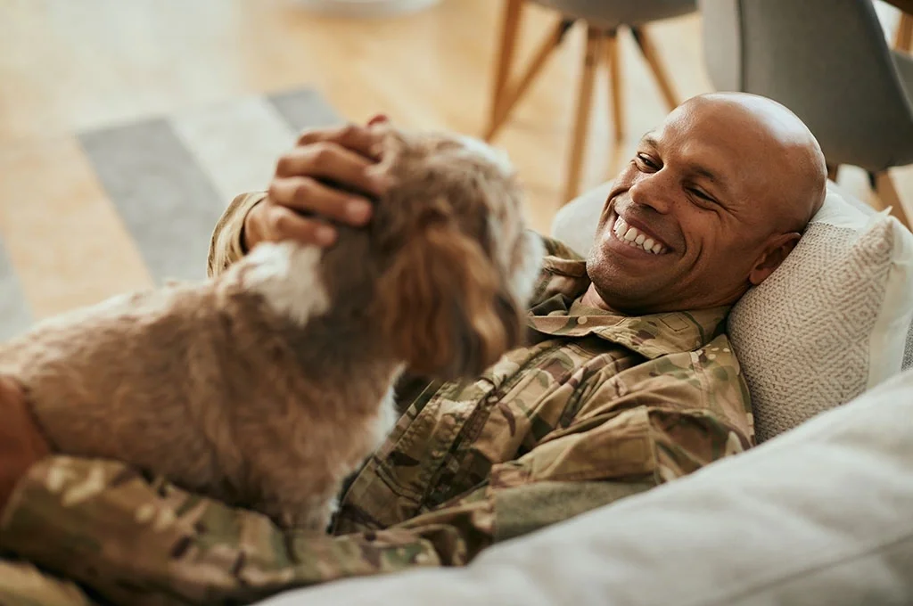 A veteran relaxing with his dog because he took advantage of veterans banking program
