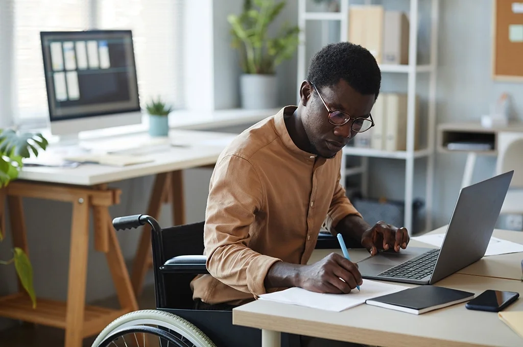 A man in a wheelchair uses a laptop to evaluate an HSA for veterans