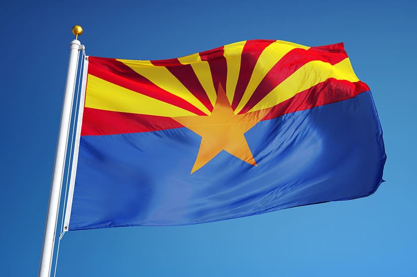 The Arizona state flag under a clear, blue sky.